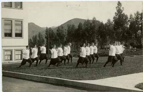 Women students performing 'gymnasium drill' with 'wands'