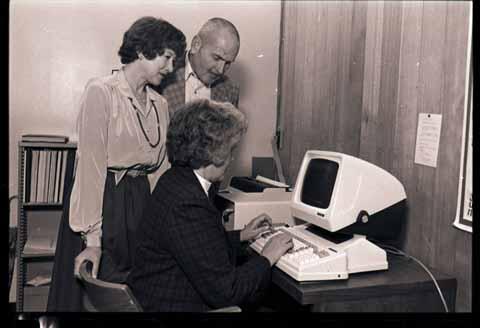 [Three people looking at a computer]