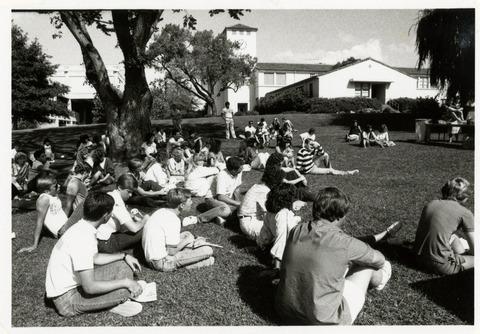 Students sitting on lawn outside Architecture building and Education building