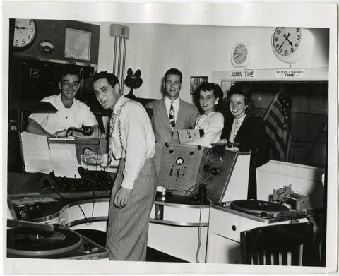 Students gathered around a switch board and turntables