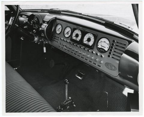 [Car dashboard with dials and controls]