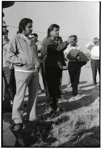 Cesar Chavez speaking (with bodyguards at his side)